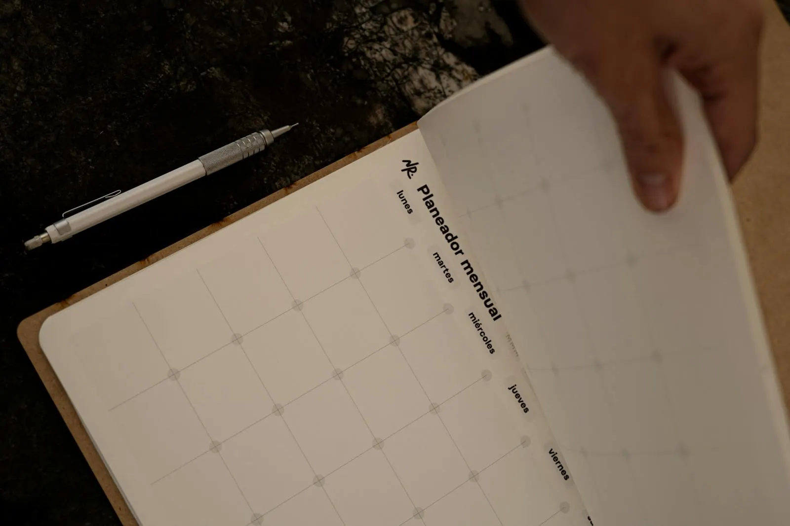 Mãos a folhear um calendário mensal